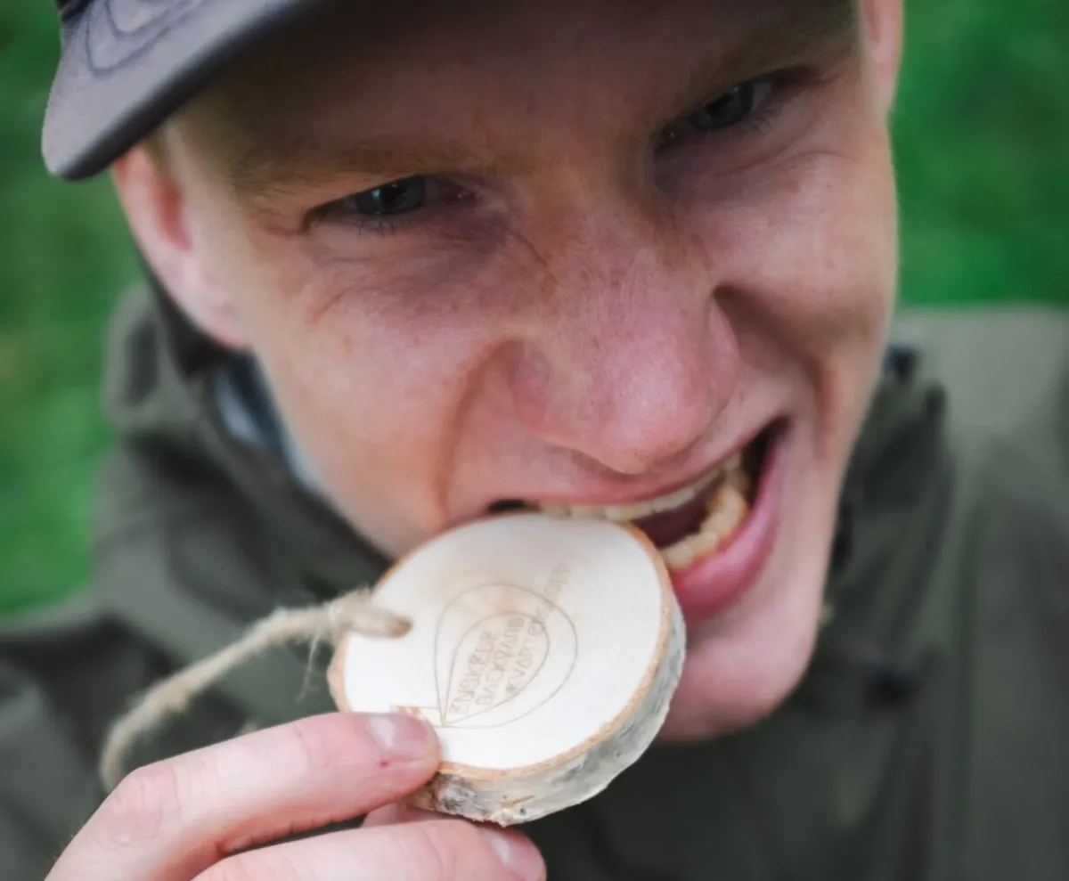 Löpare som biter i en trämedalj 