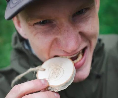 Löpare som biter i en trämedalj 